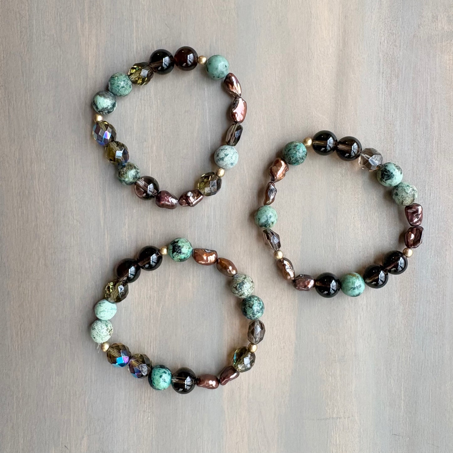 Three beaded bracelets on a wooden surface