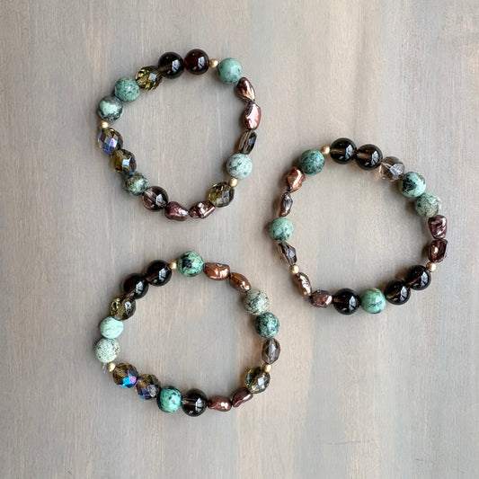 Three beaded bracelets on a wooden surface
