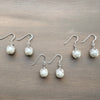 Set of pearl earrings on a wooden surface