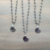 Three necklaces with shell pendants on a wooden surface