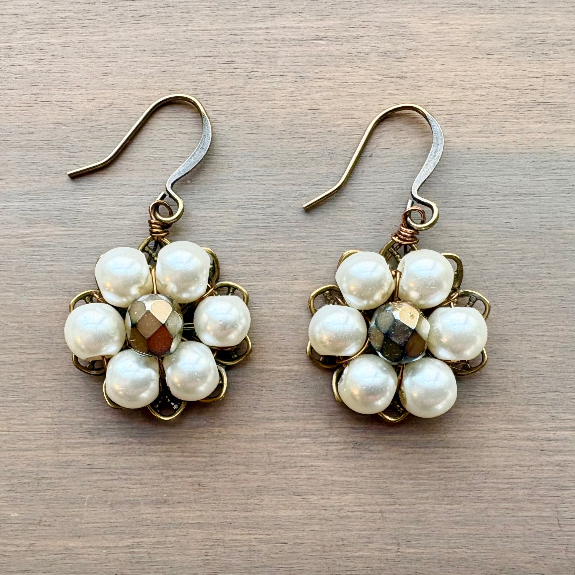 Pair of pearl earrings on a wooden surface