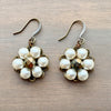 Pair of pearl earrings on a wooden surface