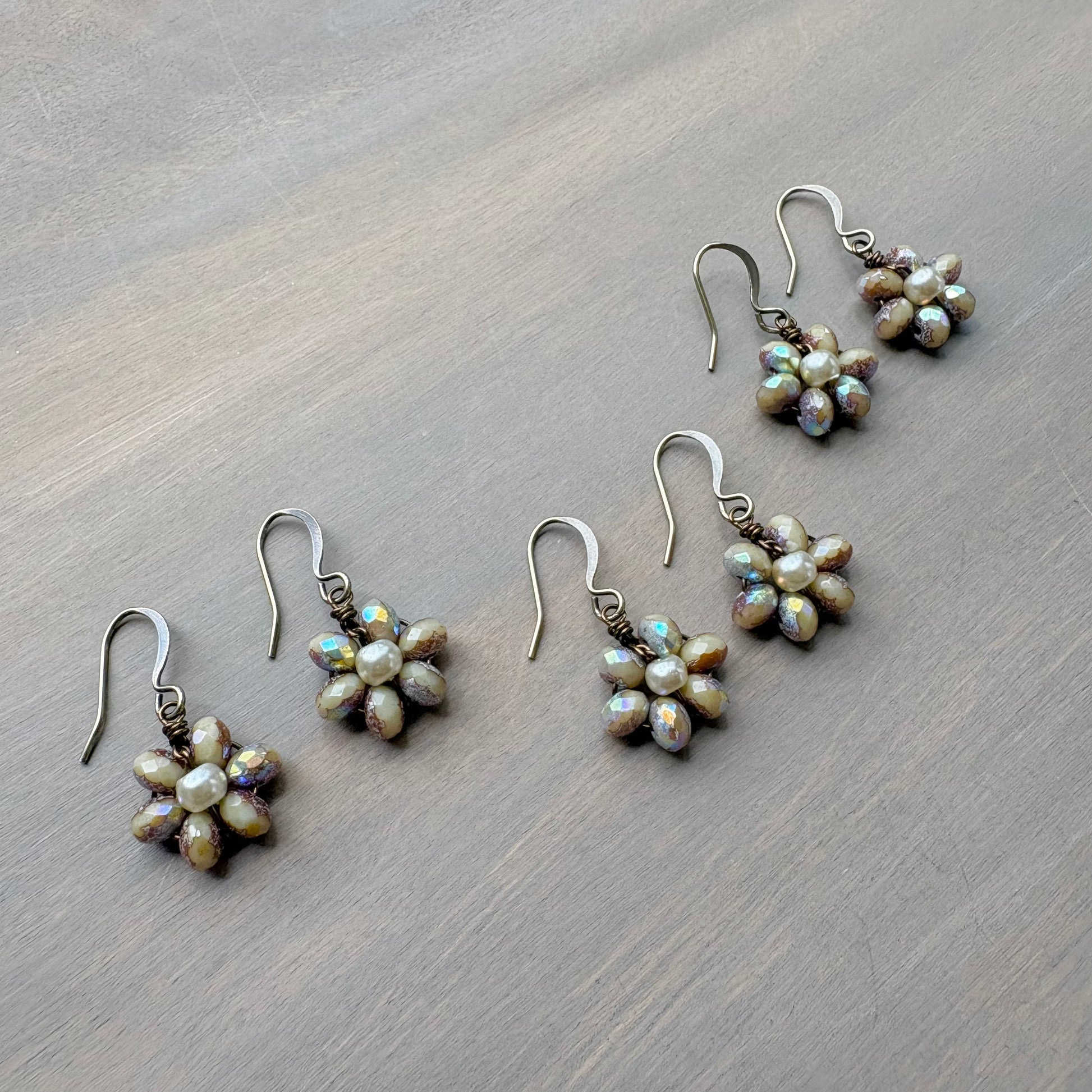 Set of pearl flower earrings on a wooden surface