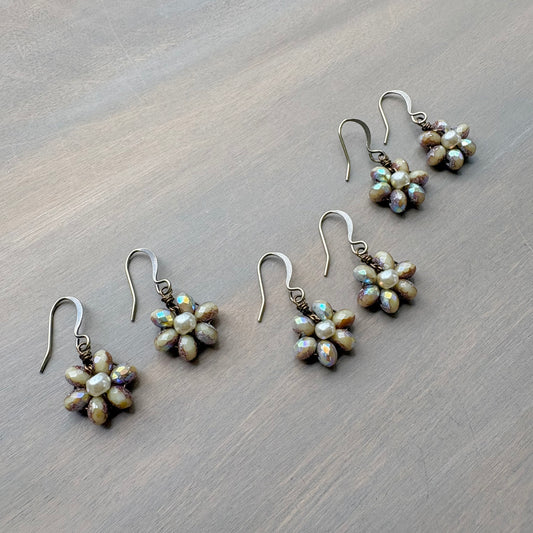 Set of pearl flower earrings on a wooden surface
