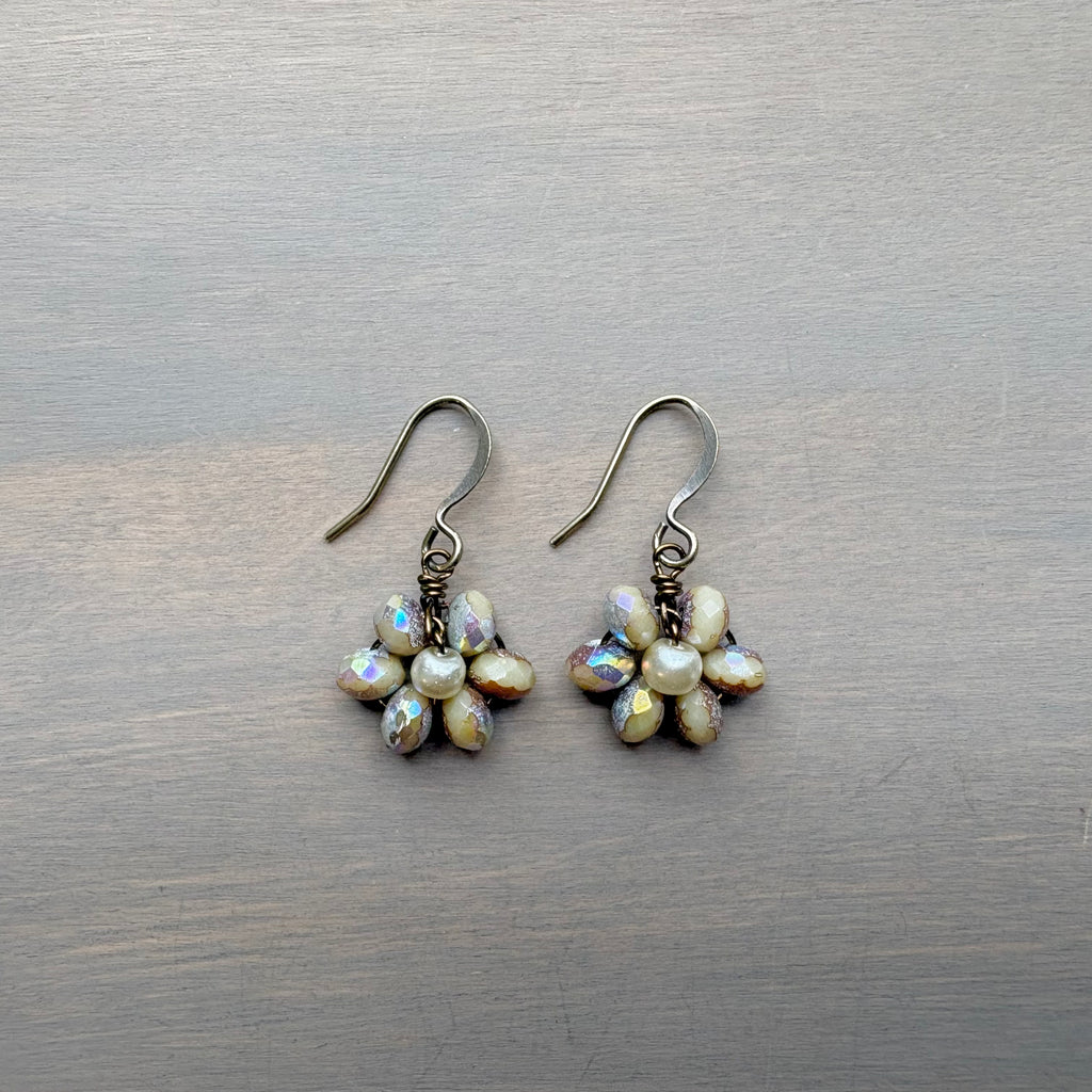 Pair of pearl flower earrings on a wooden surface