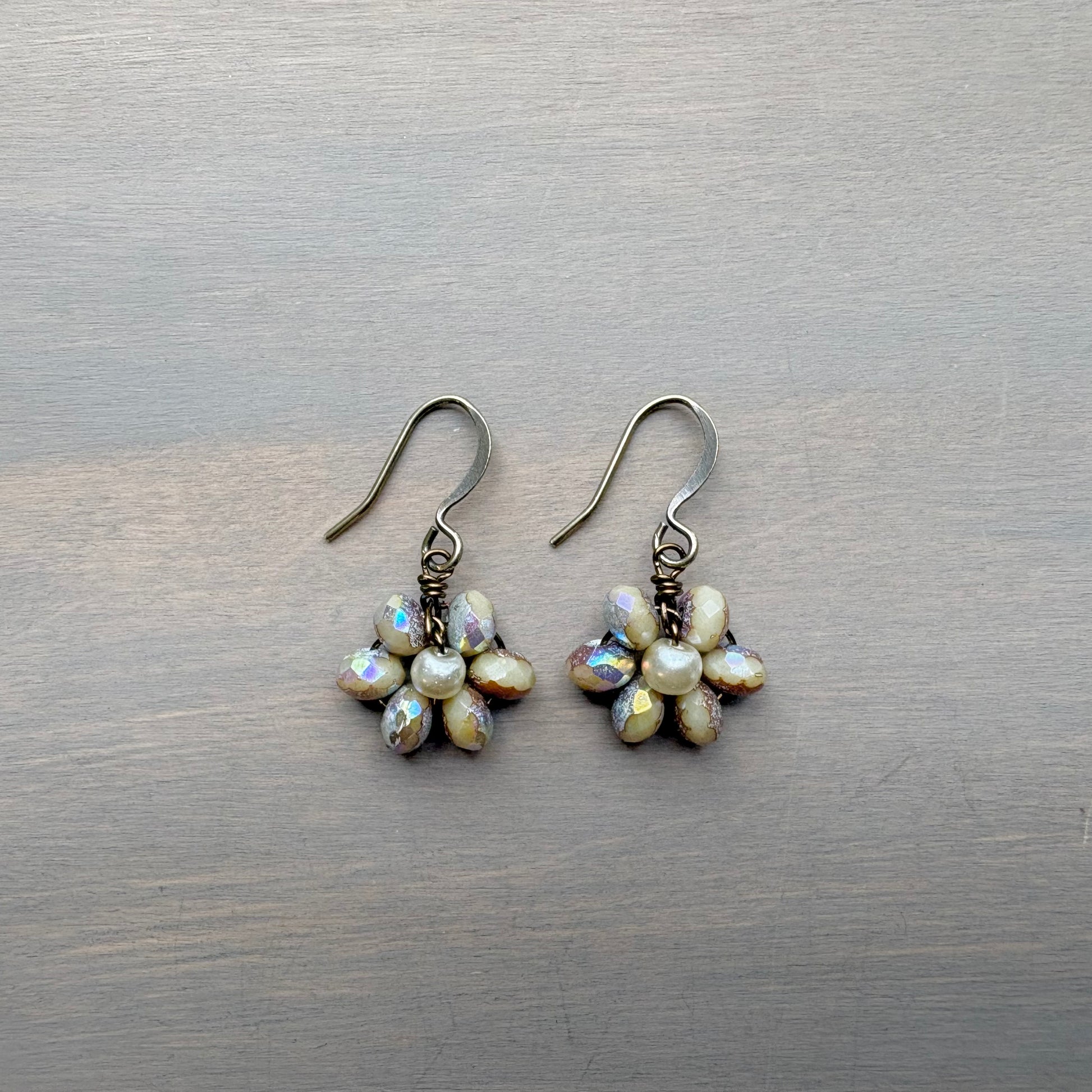 Pair of pearl flower earrings on a wooden surface