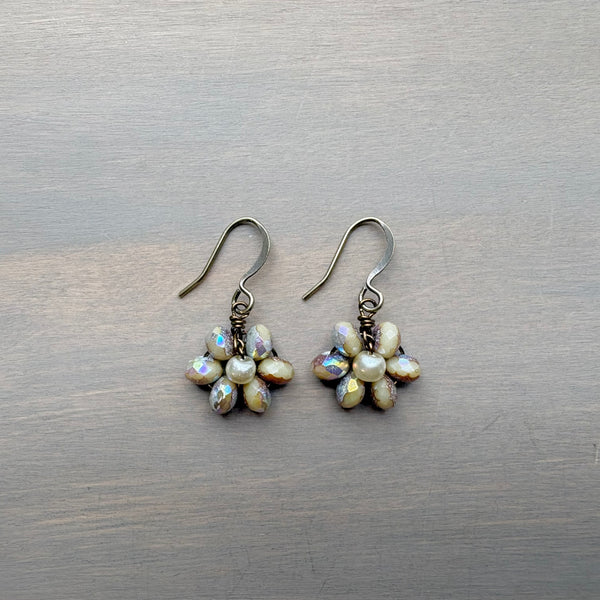Pair of pearl flower earrings on a wooden surface