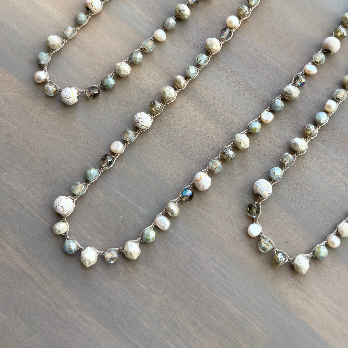 Two beaded necklaces on a wooden surface