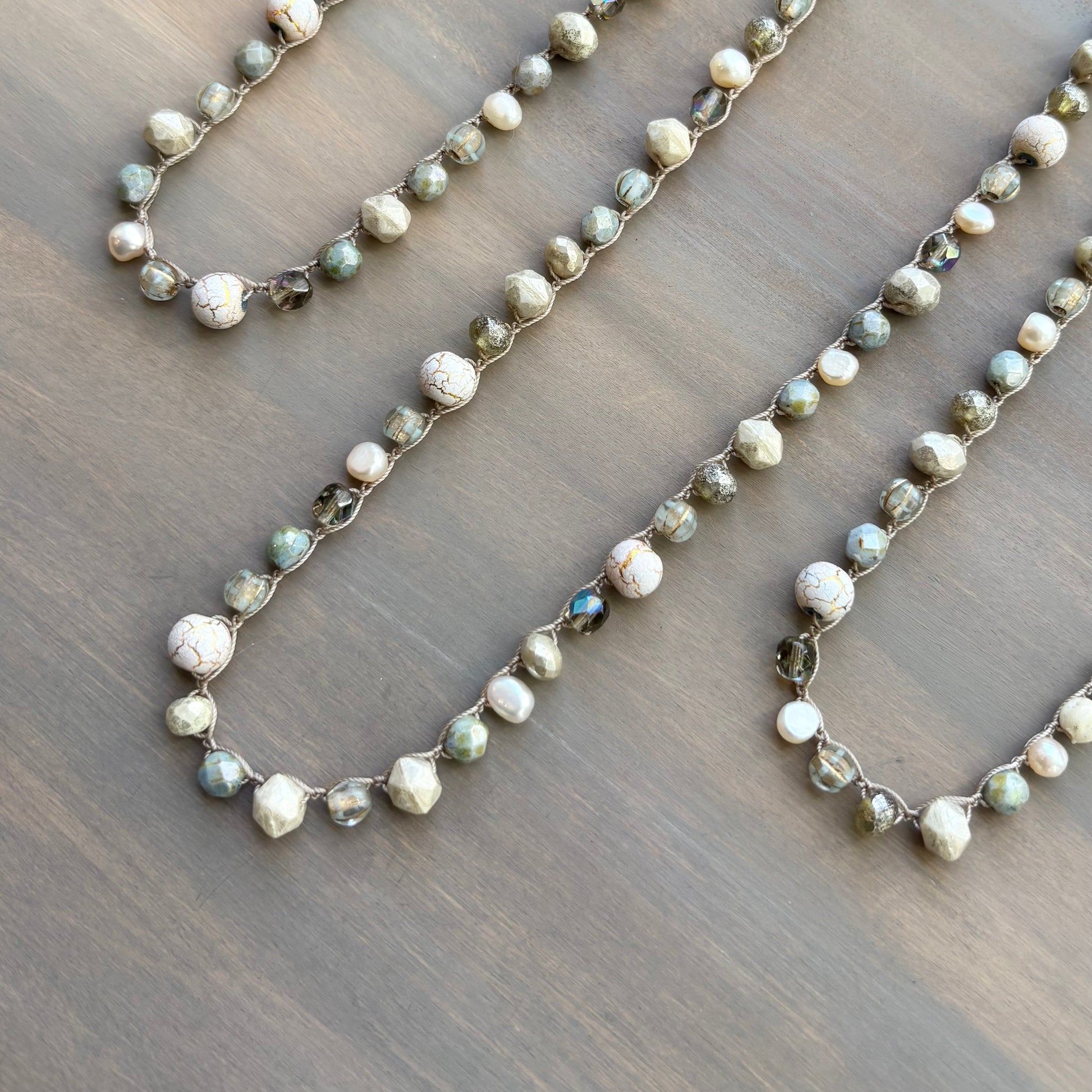 Two beaded necklaces on a wooden surface