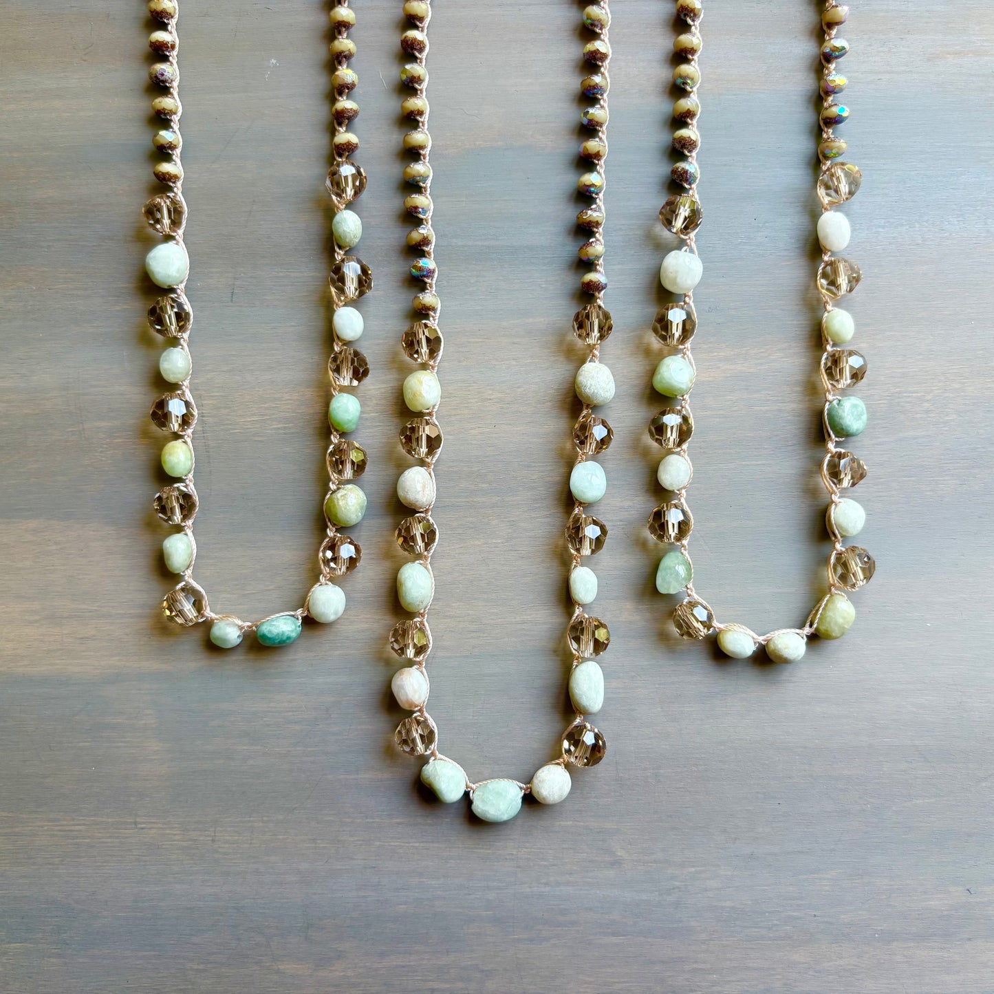 Three beaded necklaces on a wooden surface