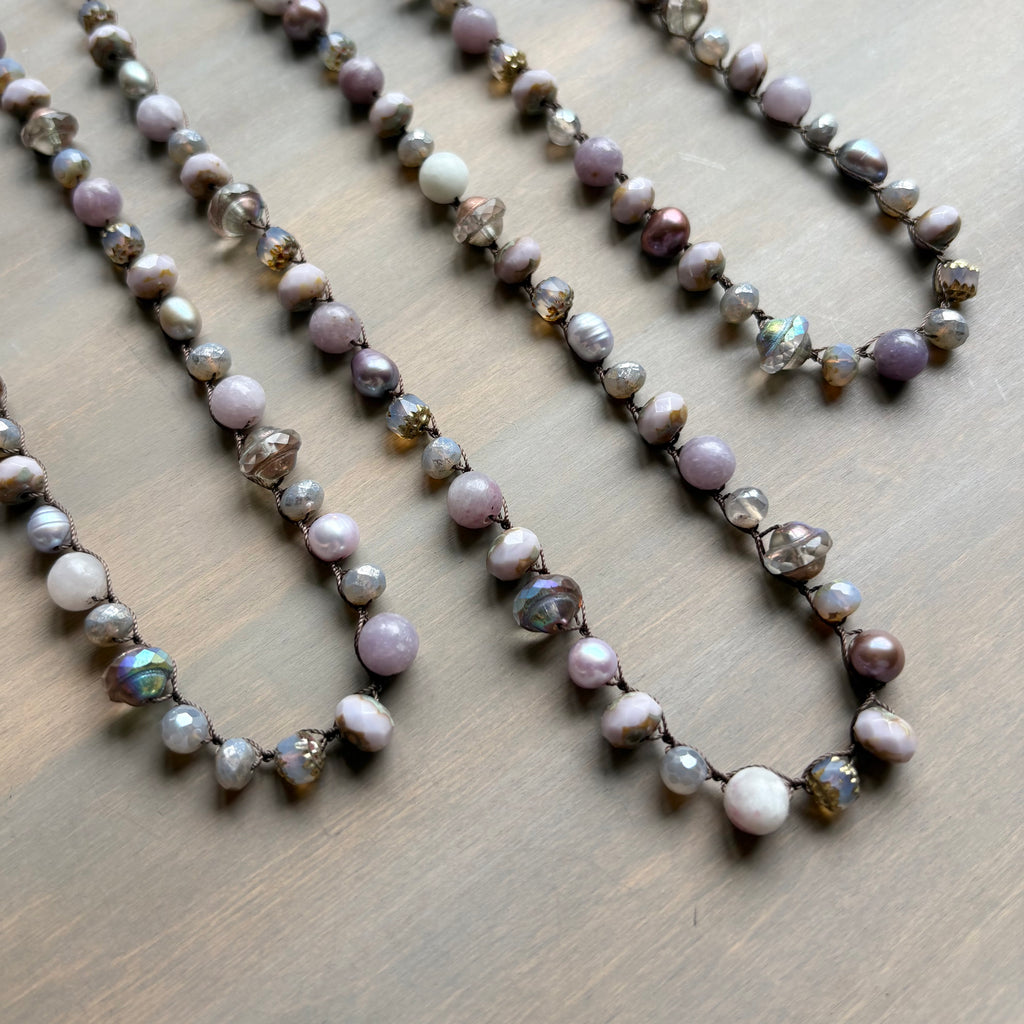 Necklace with pearls and iridescent beads on a wooden surface