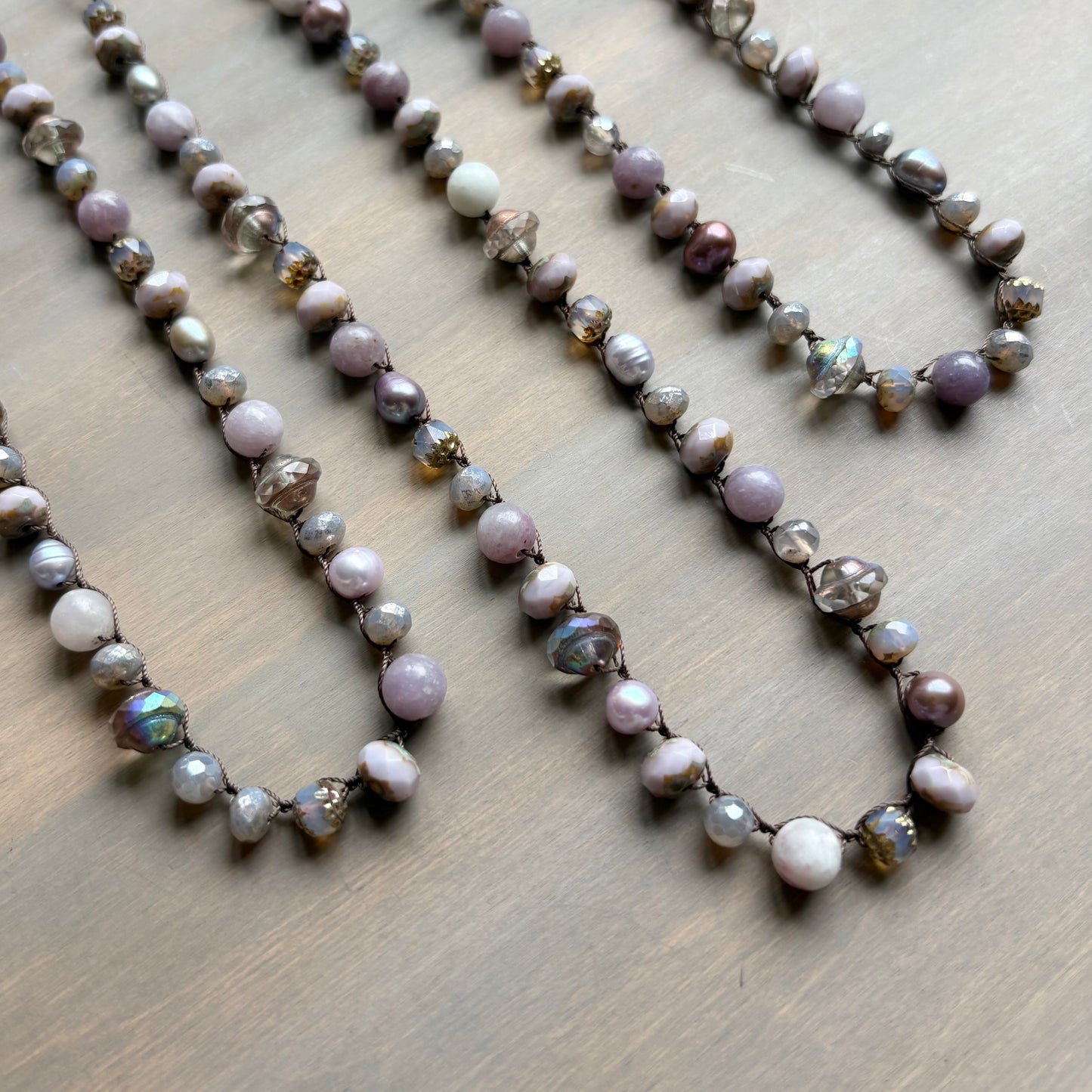 Necklace with pearls and iridescent beads on a wooden surface