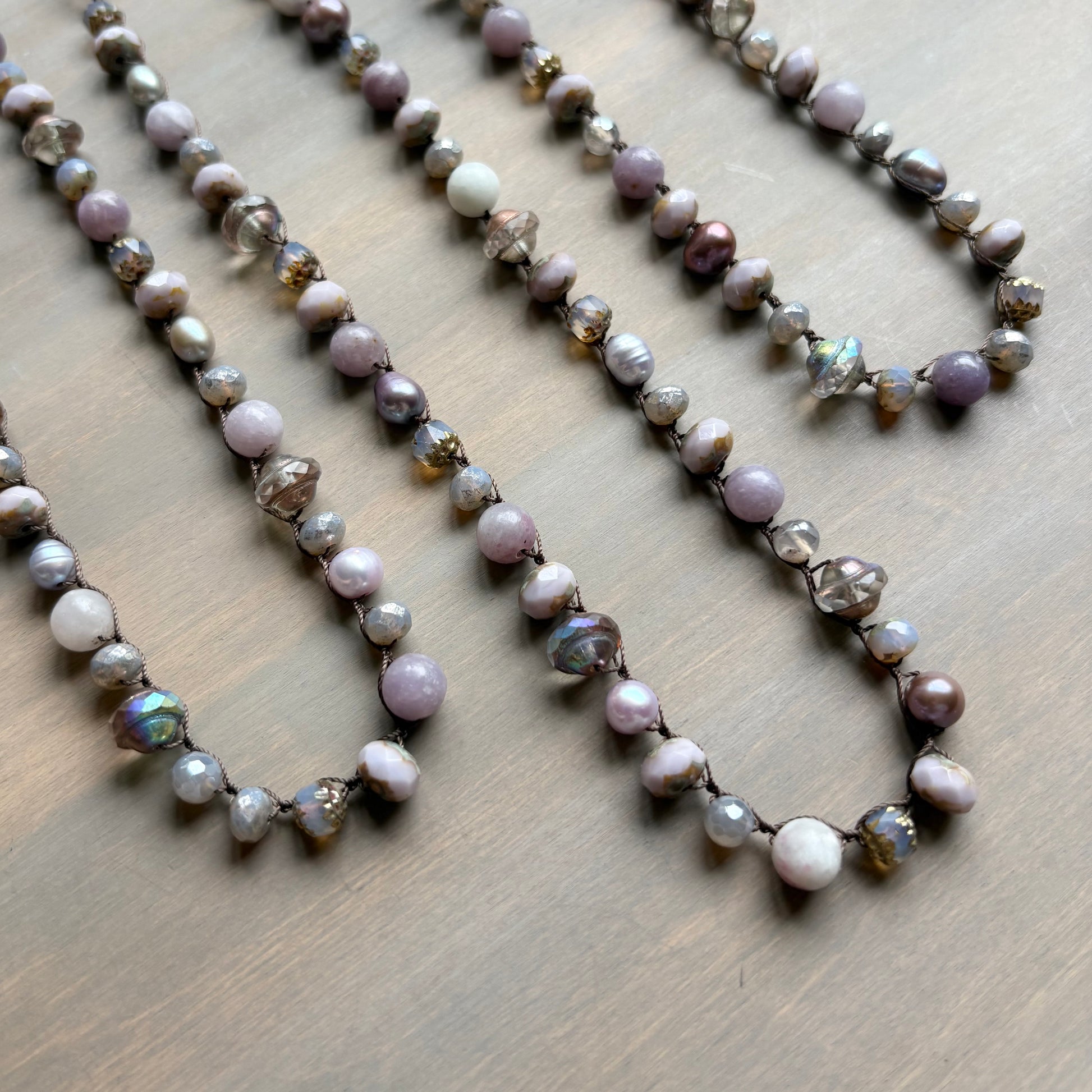Necklace with pearls and iridescent beads on a wooden surface