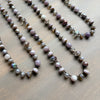 Necklace with pearls and iridescent beads on a wooden surface