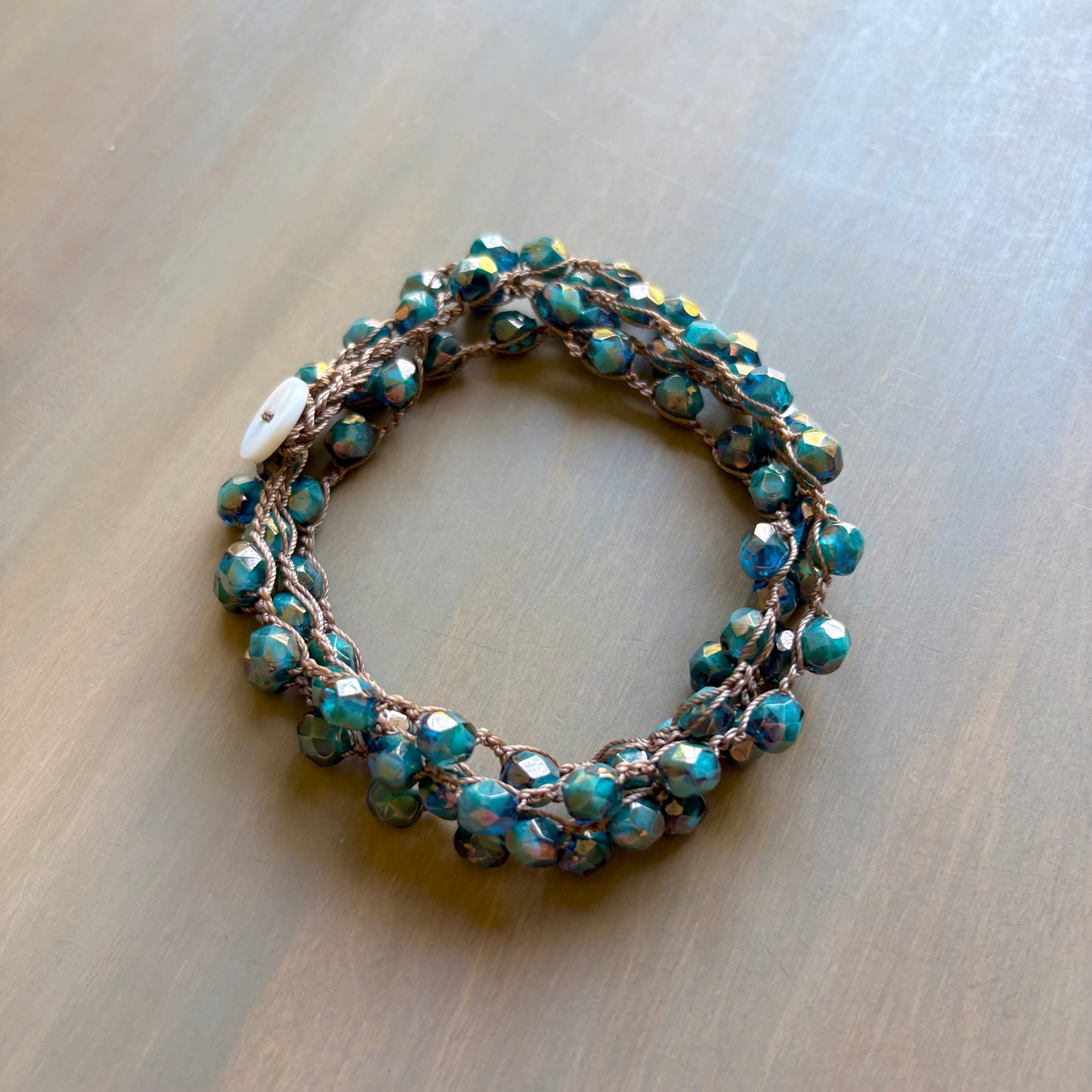 Beaded bracelet with turquoise stones on a wooden surface