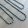 Two blue beaded necklaces on a wooden surface